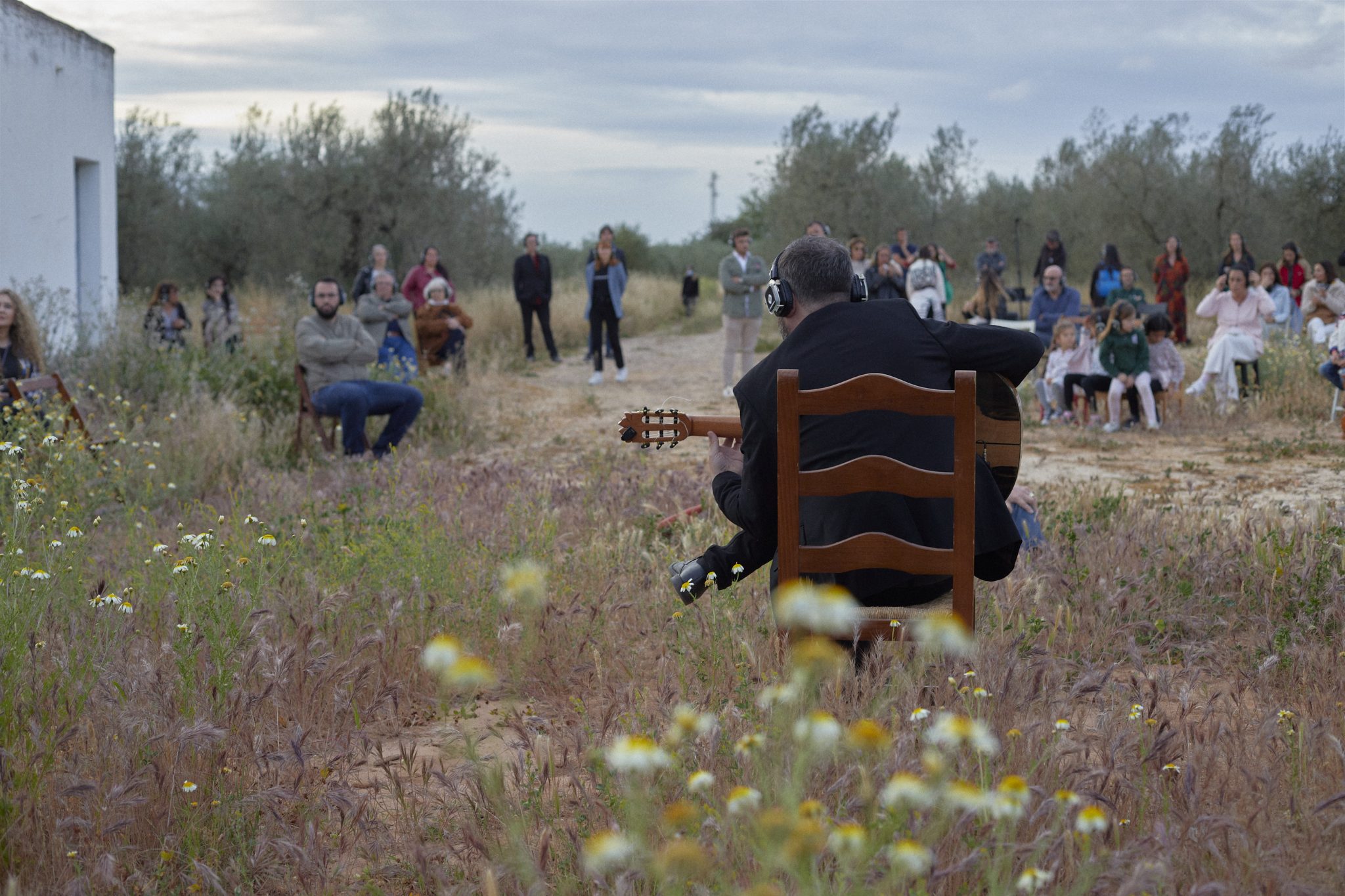 Público con auriculares inalámbricos escuchando en el olivar